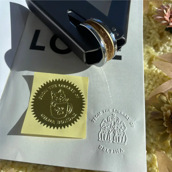 Metal stamp with a design on a piece of paper, surrounded by flowers.