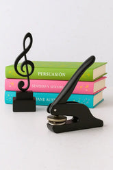 Black press with music note design on top of books